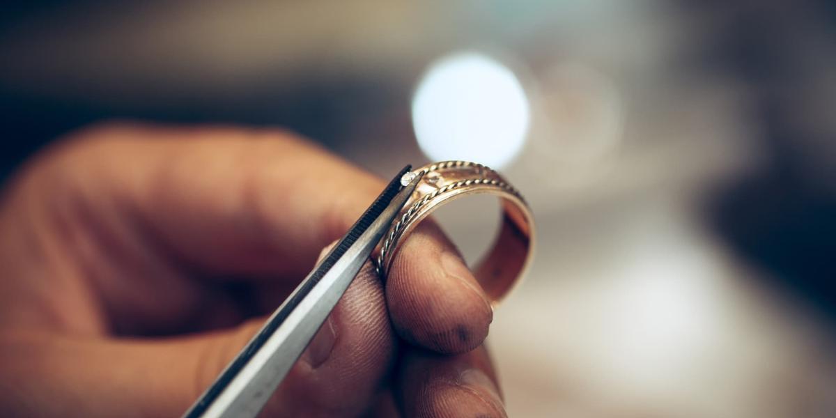 Picture of a person setting a diamond onto a ring