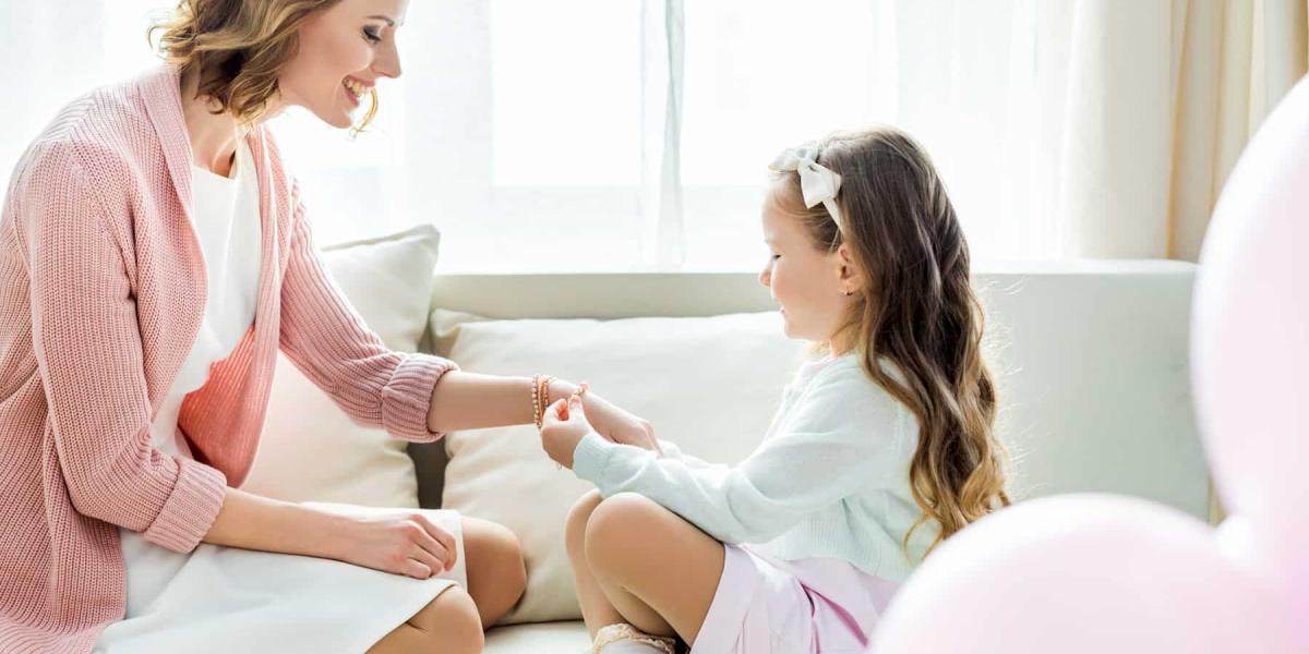 Photo of a little girl putting a bracelet on her mom