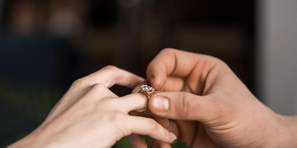 Photo of a man putting a ring on a woman’s finger