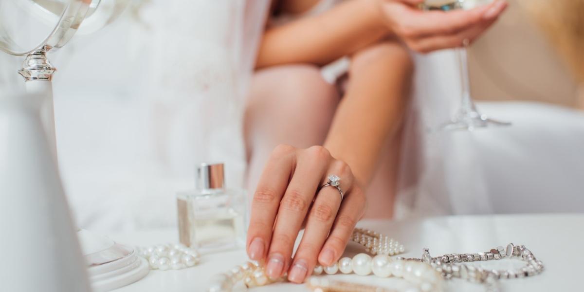 Bride wearing engagement ring and choosing pearl and diamond jewellery for her wedding day.